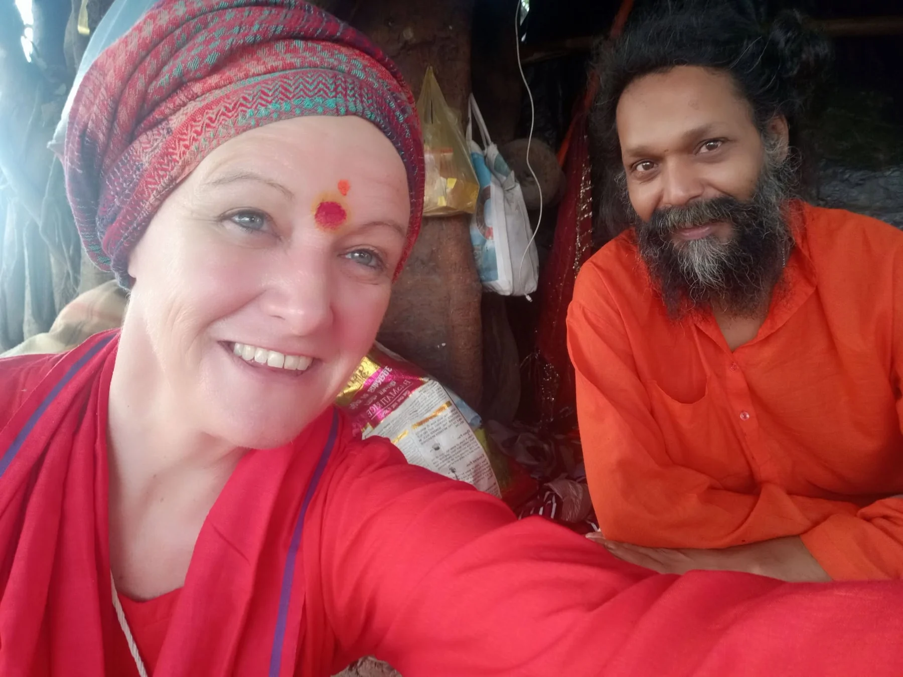 A smiling woman in a patterned head wrap beside a bearded man