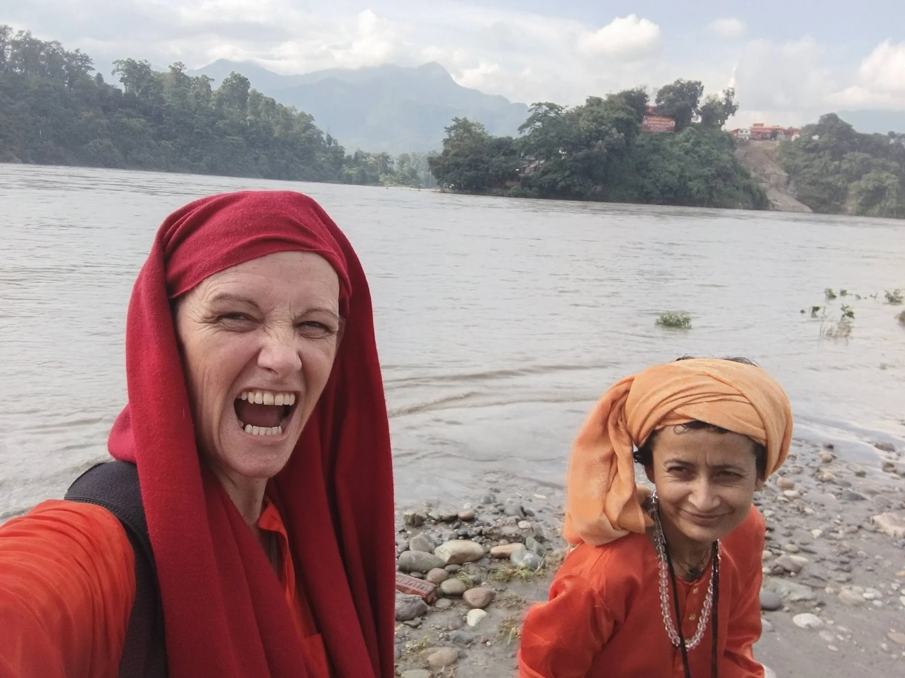 A laughing woman and her companion beside a river