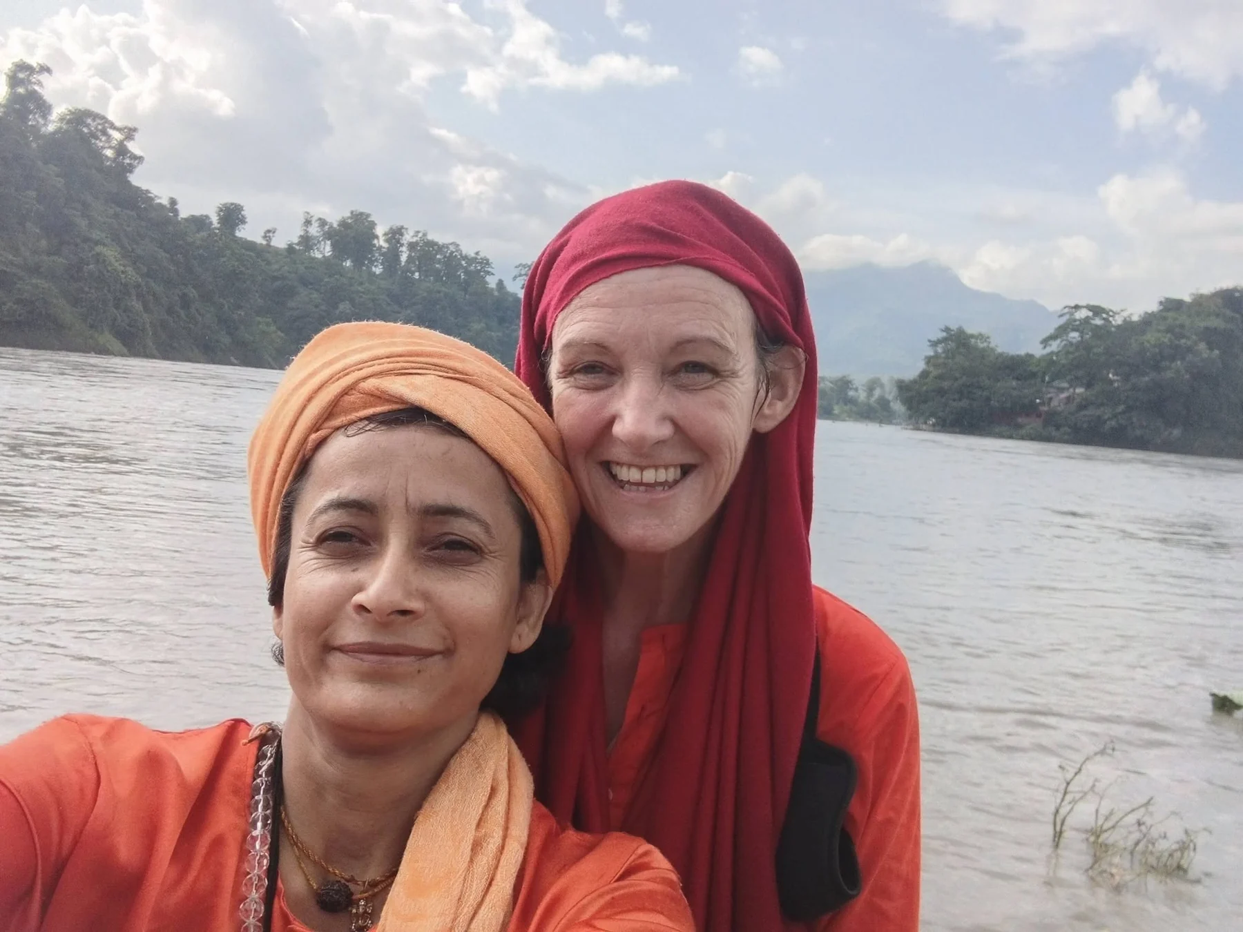 Two women posing together by the river